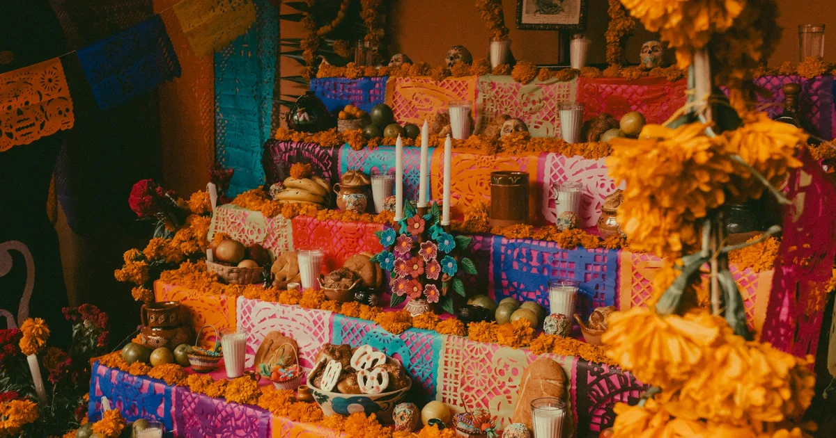Día de los Muertos ofrenda with decorated sugar skulls, candles, marigolds, and papel picado banners