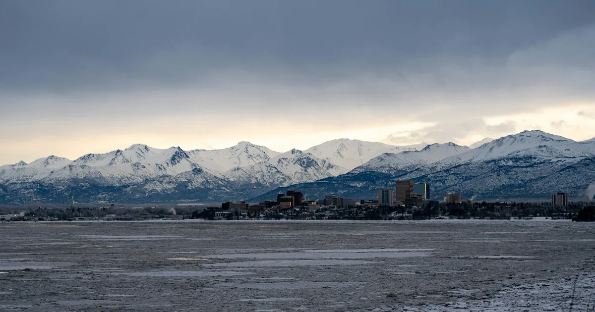 Downtown Anchorage skyline below the snow-covered Chugach Mountains