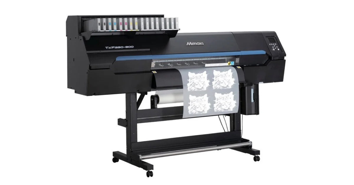 Mimaki TxF330-800 DTF printer with printed transfer film feeding out and its 16-cartridge ink bay on top