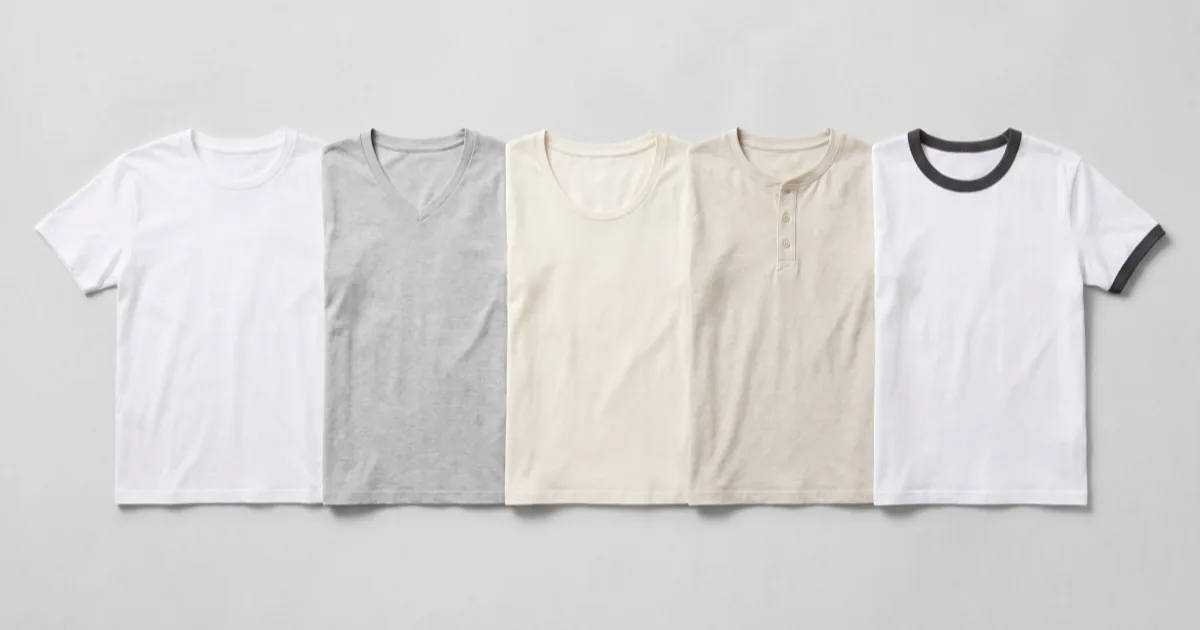 Five blank cotton t-shirts laid flat in a row showing crew neck, V-neck, scoop neck, henley and ringer necklines