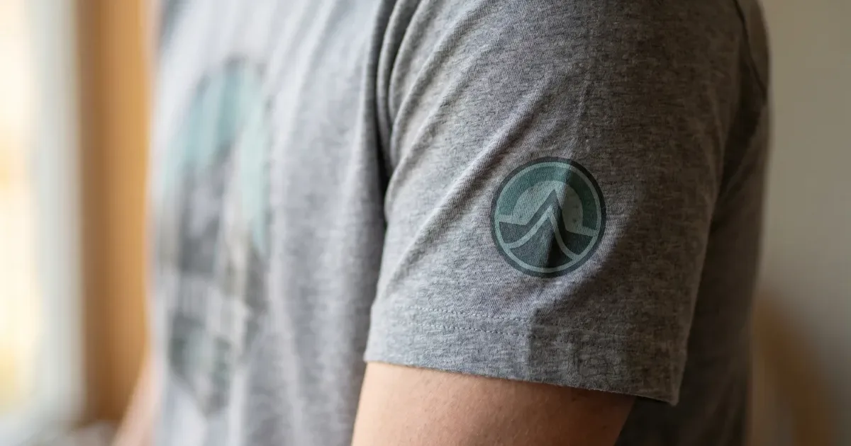 Multi-location DTF printed t-shirt showing left chest logo, full back design, sleeve print, and custom inside-collar sizing tag on a Bella Canvas tear-away blank